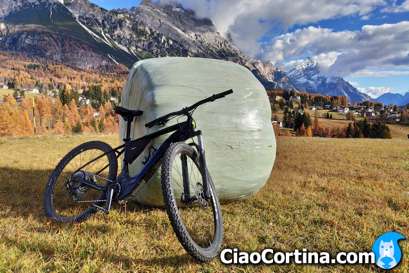 Ebike resting on hay bale with faloria mountain in the background