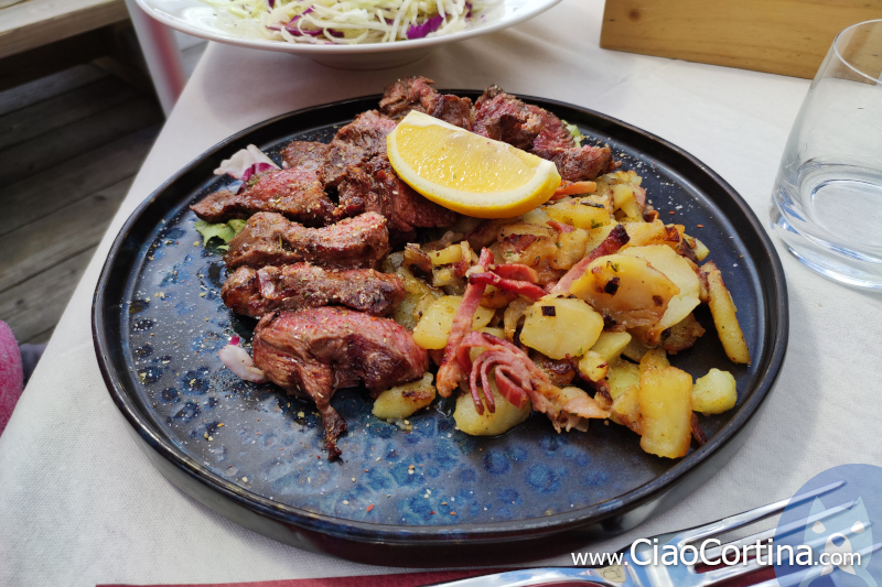 A plate of beef with side potatoes at Faloria Refuge