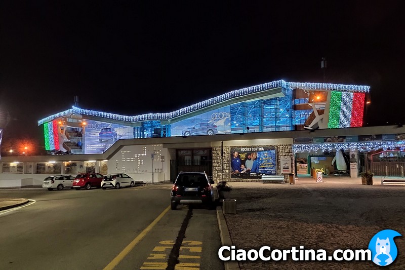 Cortina Ice Stadium illuminated with the Italian flag at night